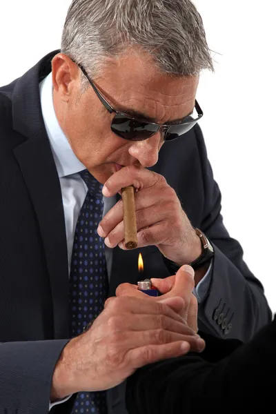 Businessman wearing sunglasses and smoking a cigar — Stock Photo, Image
