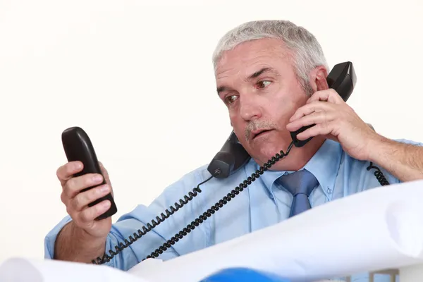 Senior architect getting multiple calls Royalty Free Stock Images