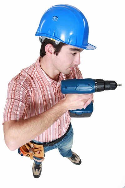 Ein Bauarbeiter hält ein Elektrowerkzeug in der Hand — Stockfoto