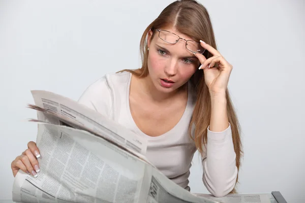 Woman shocked by newspaper article — Stock Photo, Image