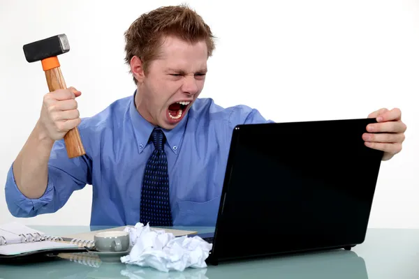 A businessman about to smash his laptop with a hammer. — Stock Photo, Image