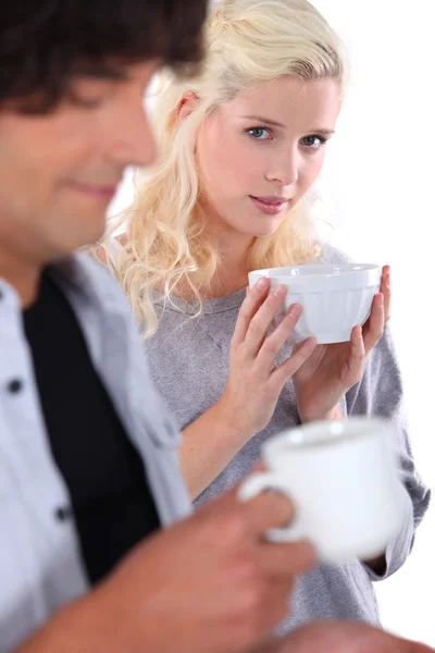 Young woman holding a bowl with man in the foreground — Stock Photo, Image