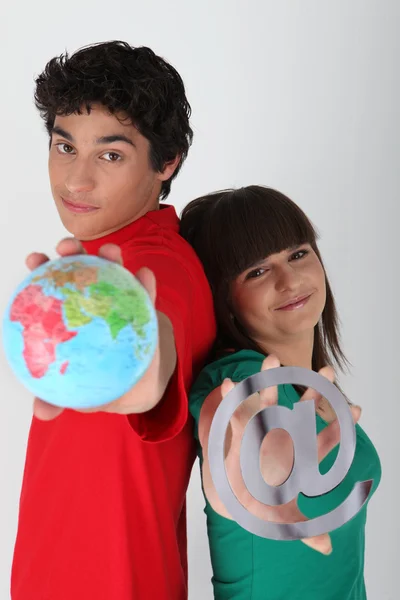 Teenager mit einem Globus und einem @ Symbol dufour _ quentin _ 140410; godreau _ lea _ 140410 — Stockfoto
