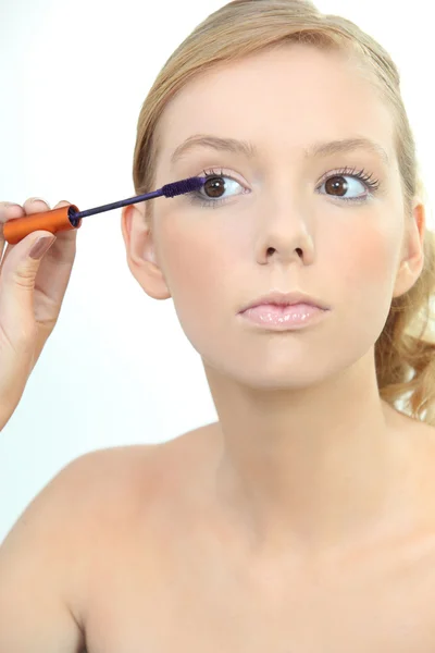 Junge Frau trägt blaue Wimperntusche auf — Stockfoto