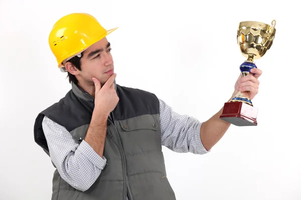 Un obrero de la construcción sosteniendo un trofeo . —  Fotos de Stock