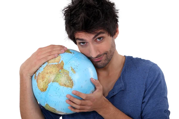 Bonito homem abraçando um globo — Fotografia de Stock