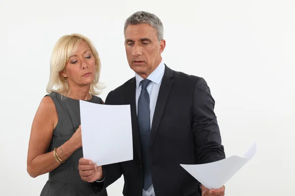 A couple of businesspeople going through papers. — Stock Photo, Image