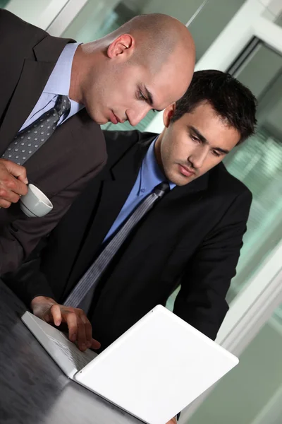 Geschäftsleute schauen auf einen Laptop — Stockfoto