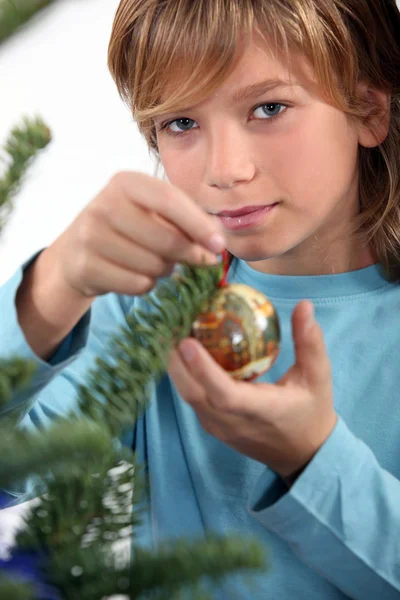 A kid decorating a Christmas tree. — Stock Photo, Image
