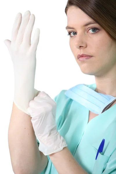 Médico femenino en matorrales tirando de un guante de goma Fotos de stock libres de derechos