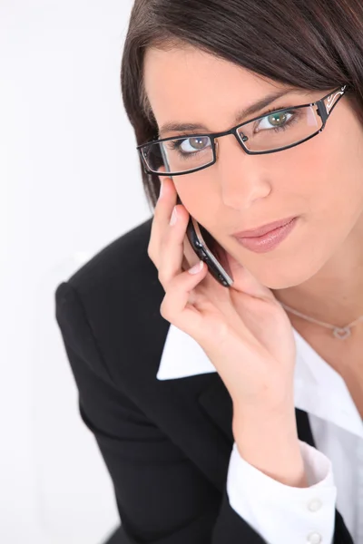 Slimme jonge vrouw dragen van een bril en het gebruik van een slanke mobiele telefoon — Stockfoto