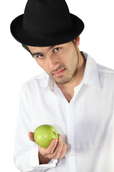 Человек в шляпе и с яблоком в руках — стоковое фото