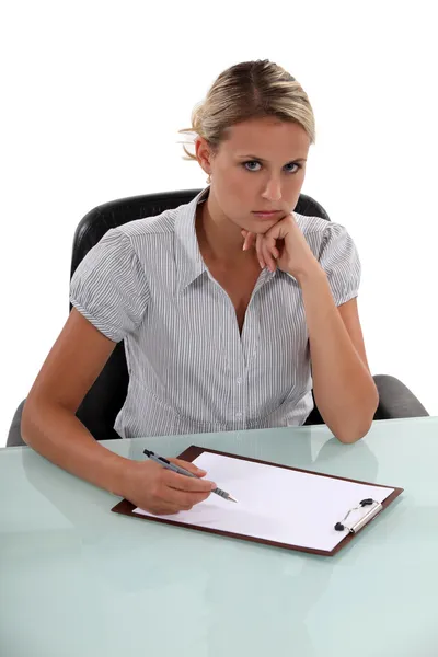 Eine eigenwillige Frau schreibt auf ein Klemmbrett — Stockfoto