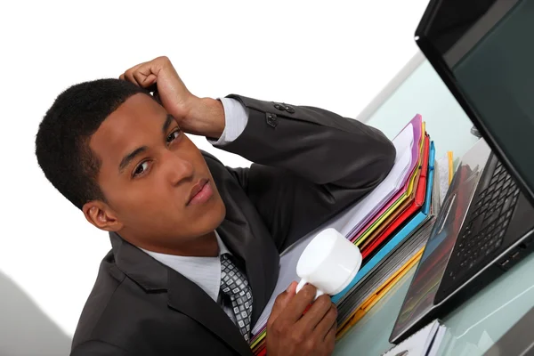 Joven hombre de negocios cansado con un café en su computadora —  Fotos de Stock
