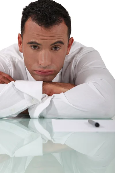 Gelangweilter Geschäftsmann sitzt an seinem Schreibtisch — Stockfoto