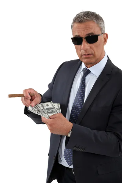 Geschäftsmann mit Zigarre und einer Handvoll Dollars — Stockfoto