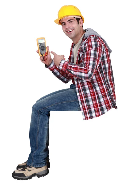 Young handsome electrician pointing at tester — Stock Photo, Image