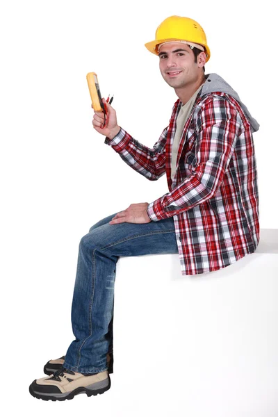 Young electrician holding a measurement tool — Stock Photo, Image