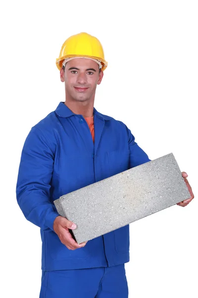 Tradesman carrying a cinder block — Stock Photo, Image