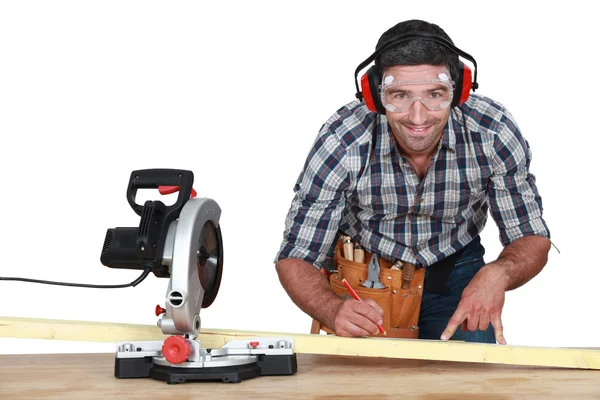 Hombre con sierra de cinta marcando madera —  Fotos de Stock