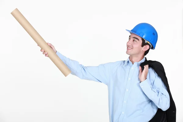 Jovem engenheiro segurando um desenho enrolado — Fotografia de Stock