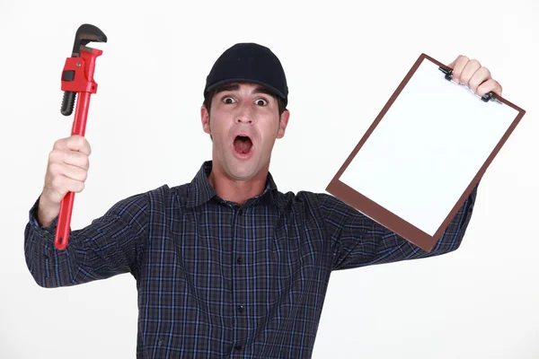 Outraged plumber holding clip-board — Stock Photo, Image