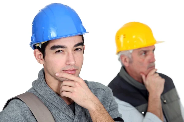 Pensive builder with young intern — Stock Photo, Image