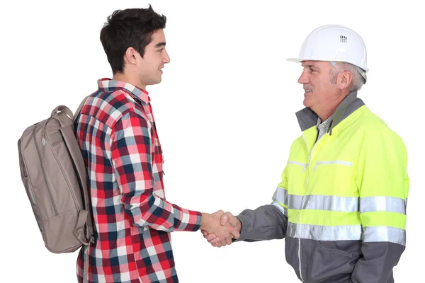 Builder welcoming apprentice Stock Image