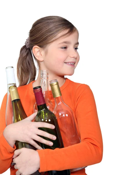 Little girl holding empty glass bottles — Stock Photo, Image