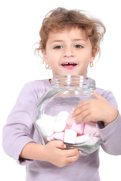 Little girl holding jar of marshmallows — Stock Photo, Image