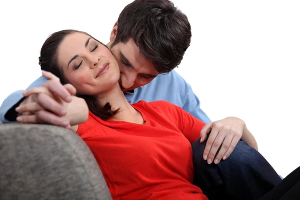 Uomo e donna teneramente abbracciati su un divano — Foto Stock