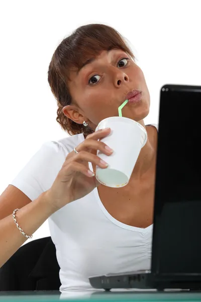 Woman drinking soft drink at desk — Stock Photo, Image