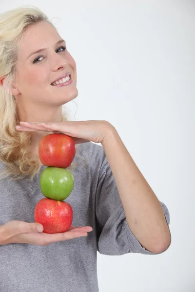 Kvinna anläggning tre äpplen — Stockfoto