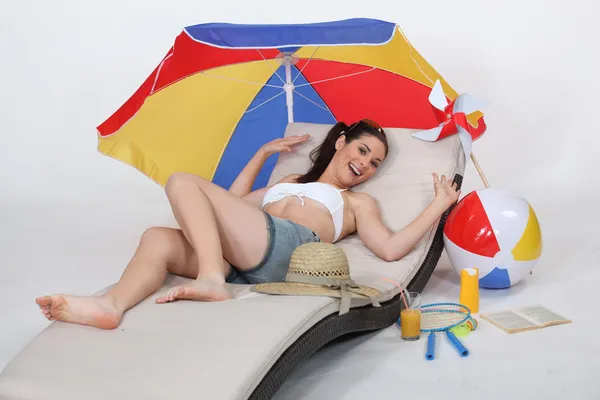 ビーチのラウンジチェアに寝そべっている魅力的な女性 — ストック写真