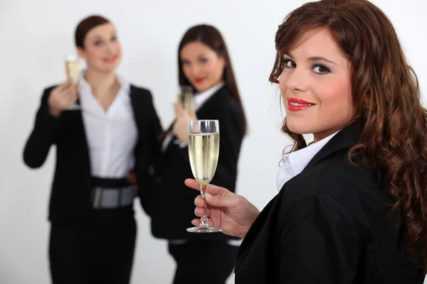 Suited women drinking champagne Royalty Free Stock Images