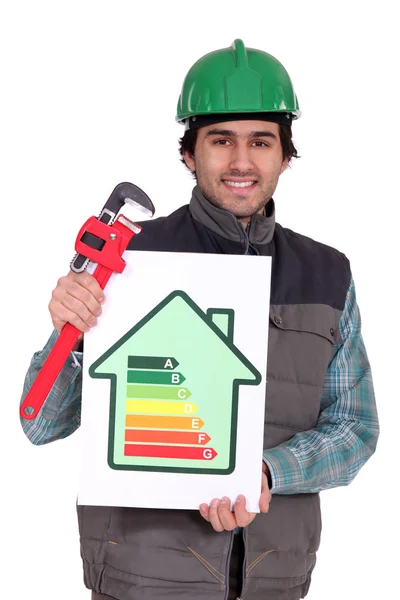Plumber holding wrench and energy rating sign — Stock Photo, Image