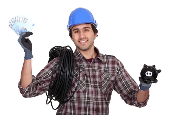 Laborer holding bills and piggy bank — Stock Photo, Image