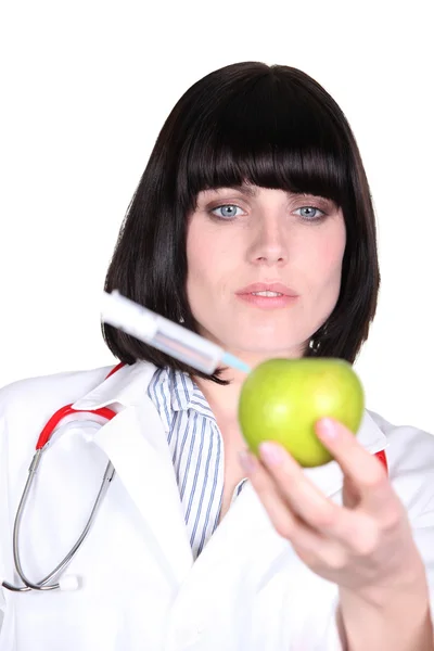 Nurse injecting syringe in apple — Stock Photo, Image