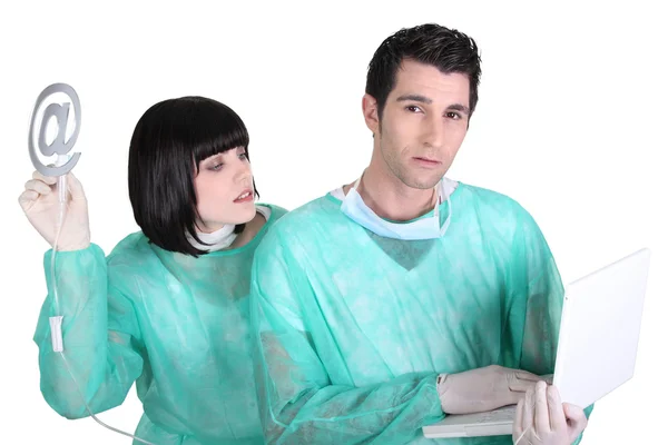 Врач и медсестра держат ноутбук и на вывеске — стоковое фото