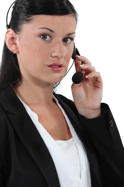 Retrato de uma recepcionista usando um fone de ouvido — Fotografia de Stock