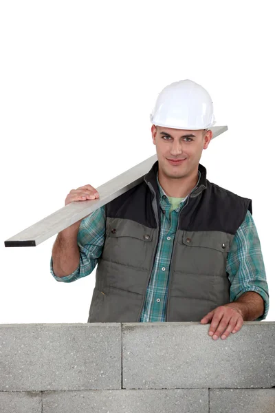 Bricklayer with a board of wood — Stock Photo, Image