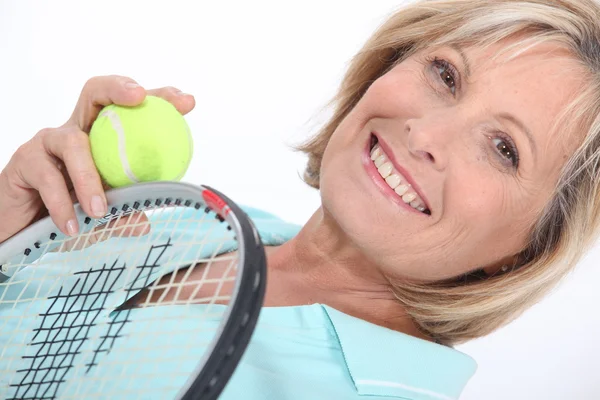 Mujer sosteniendo raqueta de tenis y pelota — Foto de Stock