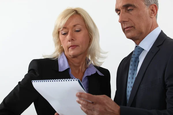 Mature business couple looking at a document Stock Image