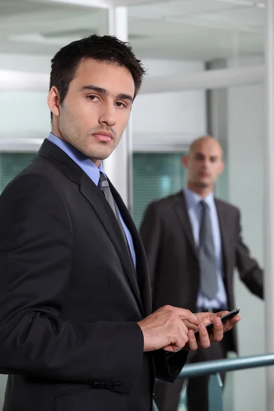 Businessman sending a message with his cell — Stock Photo, Image