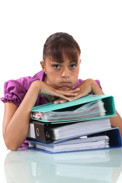 Überforderte Sekretärin sitzt auf ihrem Schreibtisch — Stockfoto