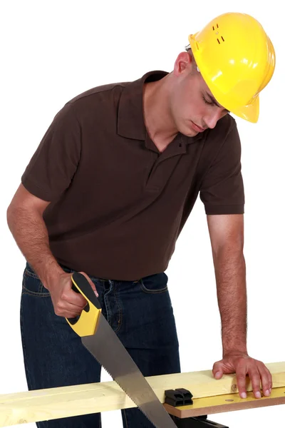 Joiner sawing a plank — Stock Photo, Image