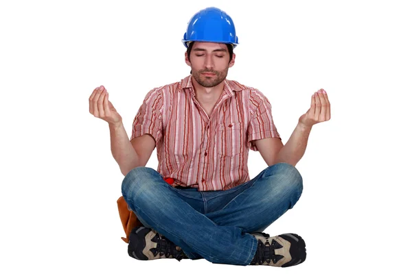 Builder sitting in yoga position — Stock Photo, Image