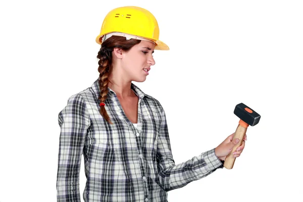 Craftswoman segurando um martelo olhando farto — Fotografia de Stock