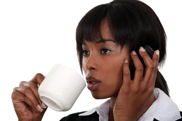 Бизнесвумен пьет кофе во время телефонного разговора — стоковое фото