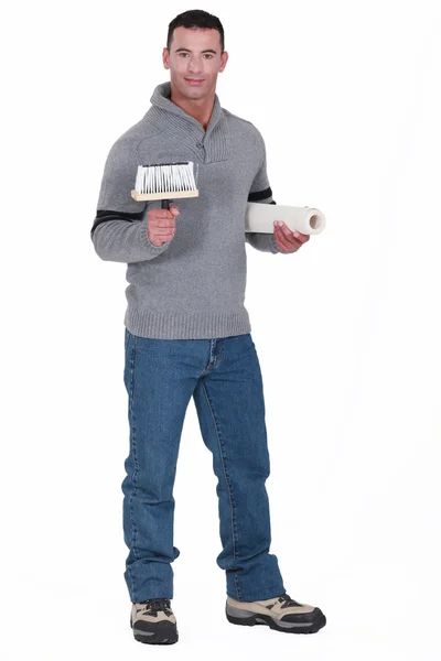 Man holding roll of wallpaper and brush — Stock Photo, Image